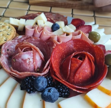 A beautifully crafted flower of salami and pepperoni on a gourmet charcuterie board featuring an ass