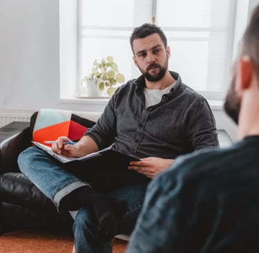 Ein Berater hört seinem Klienten aufmerksam zu und macht sich Notizen
