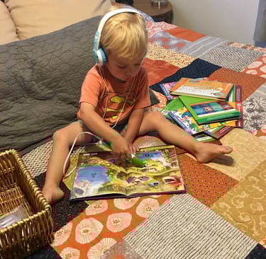 boy reading on bed with headphones