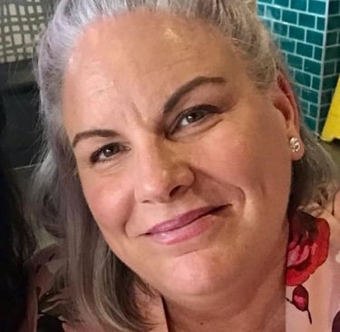 a woman with grey hair and a pink shirt