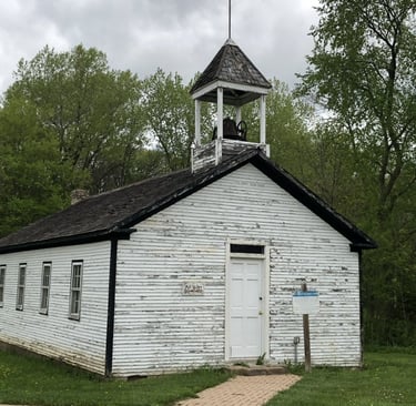 A white wooden church with a bell