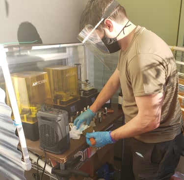 Pictured: Our founder operating three resin 3D printers to produce our first design project (2021).
