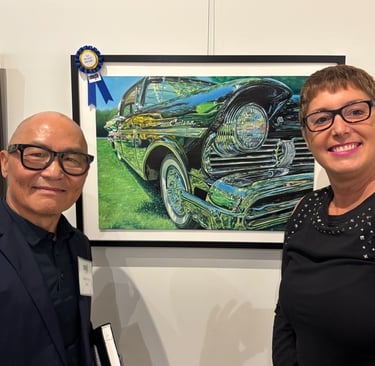 Photo of Sue and Peter Cheung (Judge) displaying 2nd place win painting