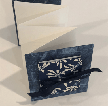 Accordion with Japanese paper and small accordion on cover, ribbon detail