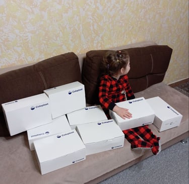 маленька дівчинка сидить на дивані з ящиками коробок