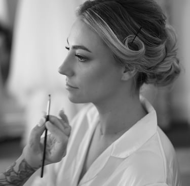 a woman getting makeup done by a professional makeup artist