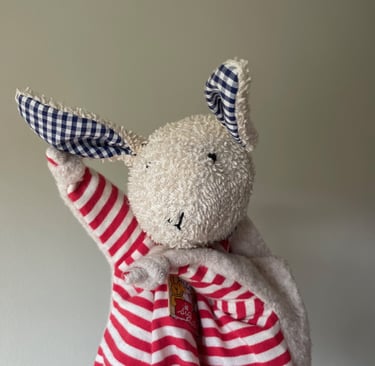 a stuffed animal rabbit dressed in a red and white striped dress