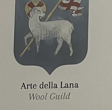 a medieval guild emblem of a sheep carrying a white flag with a red cross