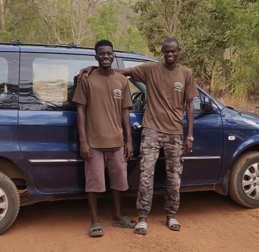 Twee gidsen van Birding Adventures Gambia & Senegal naast een blauwe minibus, gebruikt voor comforta