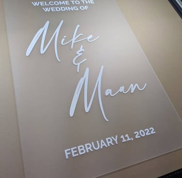 Acrylic wedding welcome sign for Mike and Maan dated February 11, 2022, displayed on a printing bed.