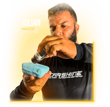 Professional car detailing specialist applying ceramic coating liquid to a blue applicator sponge.