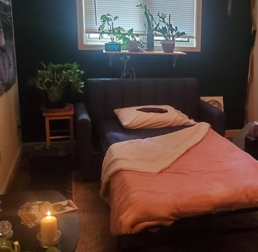 A psychedelic therapy room, set up with a bed, candles, speakers, plants and artwork