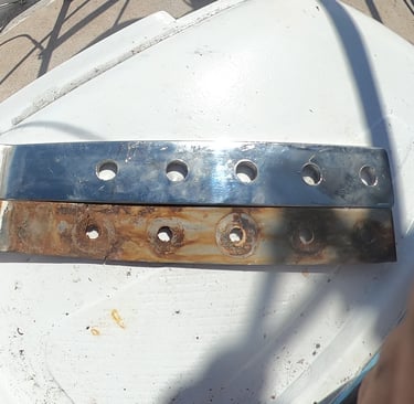 Old rusty chainplate next to new polished stainless steel replacement