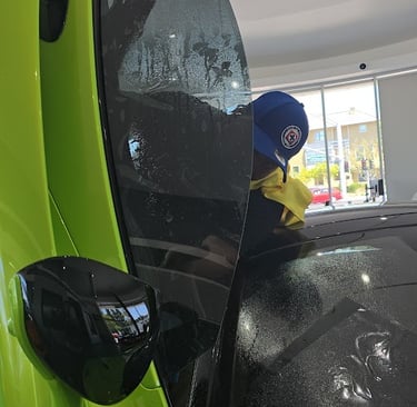bluemax Technician intalling window film on a mclaren windows