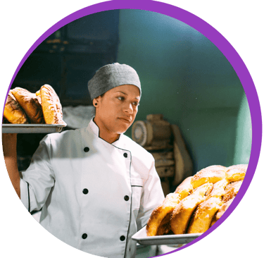 Dans un cadre, une femme avec deux plateaux de viennoiseries