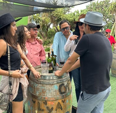 Grupo de amigos conversando junto a barril en viñedo de Querétaro