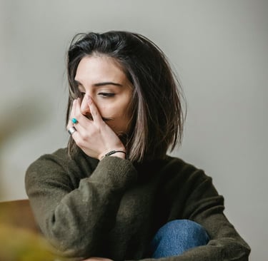 femme dont le visage et la posture indique une difficulté émotionnelle