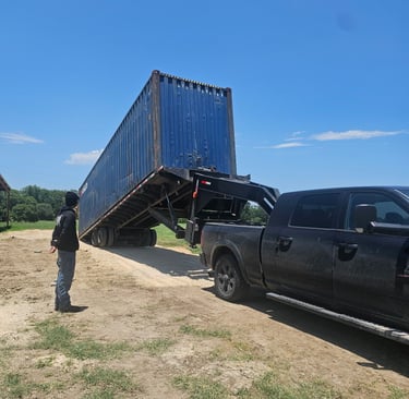 A 40ft blue cargo worthy container on a tilted trailer to be off loaded