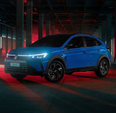 vw nivus 2025 na cor azul com os faróis acesos e retroiluminado por uma luz avermelhadem uma garagem
