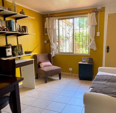 Interior de sala de estar con paredes amarillas y zona de trabajo | proyecto del Studio Atípico