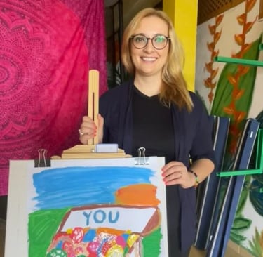 a woman holding a painting of a house