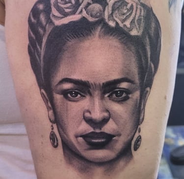Realistic leg tattoo of Freida Khalo's face by contemporary Puerto Rican artist Miguel Pena