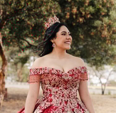 Hermoso retrato profesional de quinceaños con vestido rojo en Itchimbía Quito con naturaleza y sonrisa de felicidad