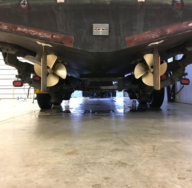 a large boat sitting in a garage props rudders