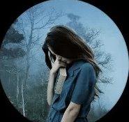 Mid shot of a young woman with long dark hair looking down and holding a book - image is framed by a black vignette