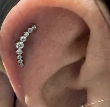 Close-up of professional helix piercing with titanium stud in Montrose