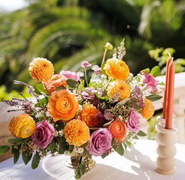 composition florale teintes vives et bougies oranges