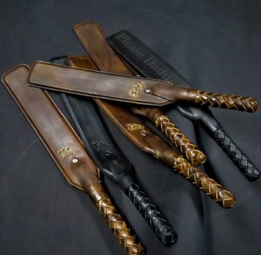 a set of leather paddles with braided handles