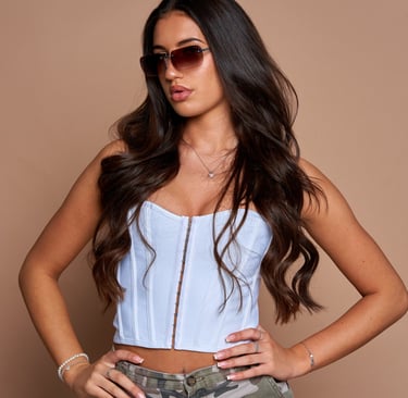 A model in a white tank top and camo pants