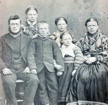 A bearded man, his wife, three daughters and one son in traditional dress circa 1890s