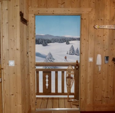 Trompe-l'oeil réalisé sur une porte d'entrée. Il représente un paysage enneigé avec barrière en bois