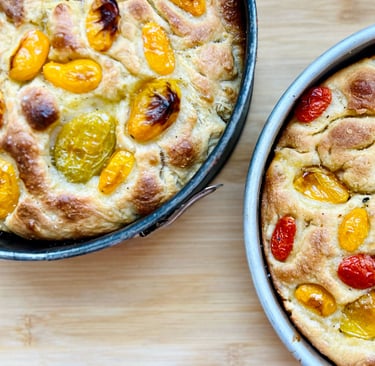 focaccia baked and presented on the mold with market tomatoes