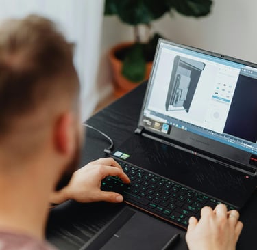 a man sitting at a desk with a laptop computer estimating a custom 3d project
