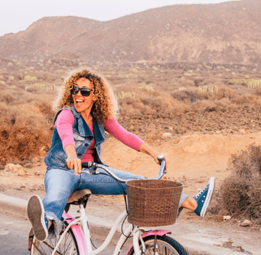 Smiling woman riding a bicycle enjoying freedom from pelvic pain