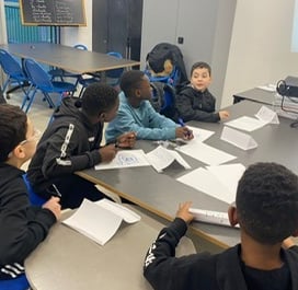 a group of children sitting around a table