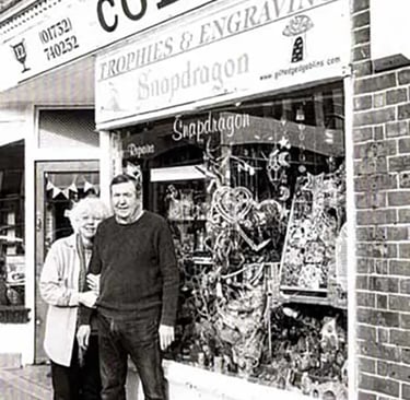 a man and woman standing in front of a store
