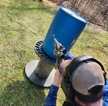 Man engaging targets from a barrier using self-defense firearm during training.