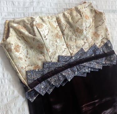 The front of the bodice of a gold brocade and brown satin evening gown