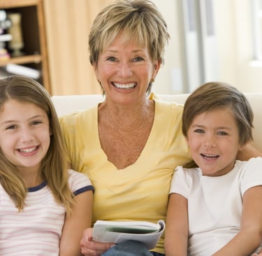 a woman sitting on a couch with two children
