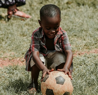 a young boy is playing with a soccer ball