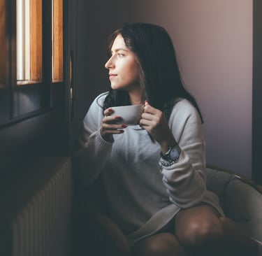 Woman, sips tea calmly, feeling relief from nerve pain and tingling in her hands