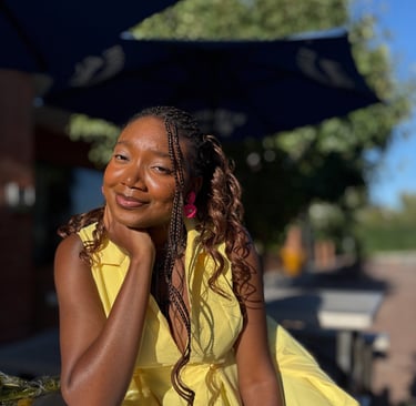 Iheoma Uzomba in yellow dress smiling