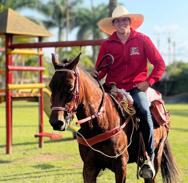 a man in a red shirt and hat riding a horse
