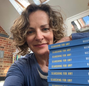 author with a pile of copies of Searching for Amy