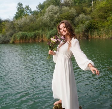 Celina Lerchner steht mit Blumen auf Baum im See
