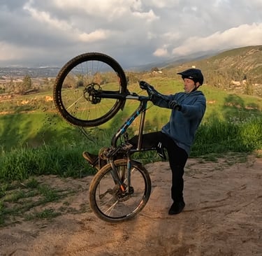 mountain biker stepping off back of bike after loopout on wheelie